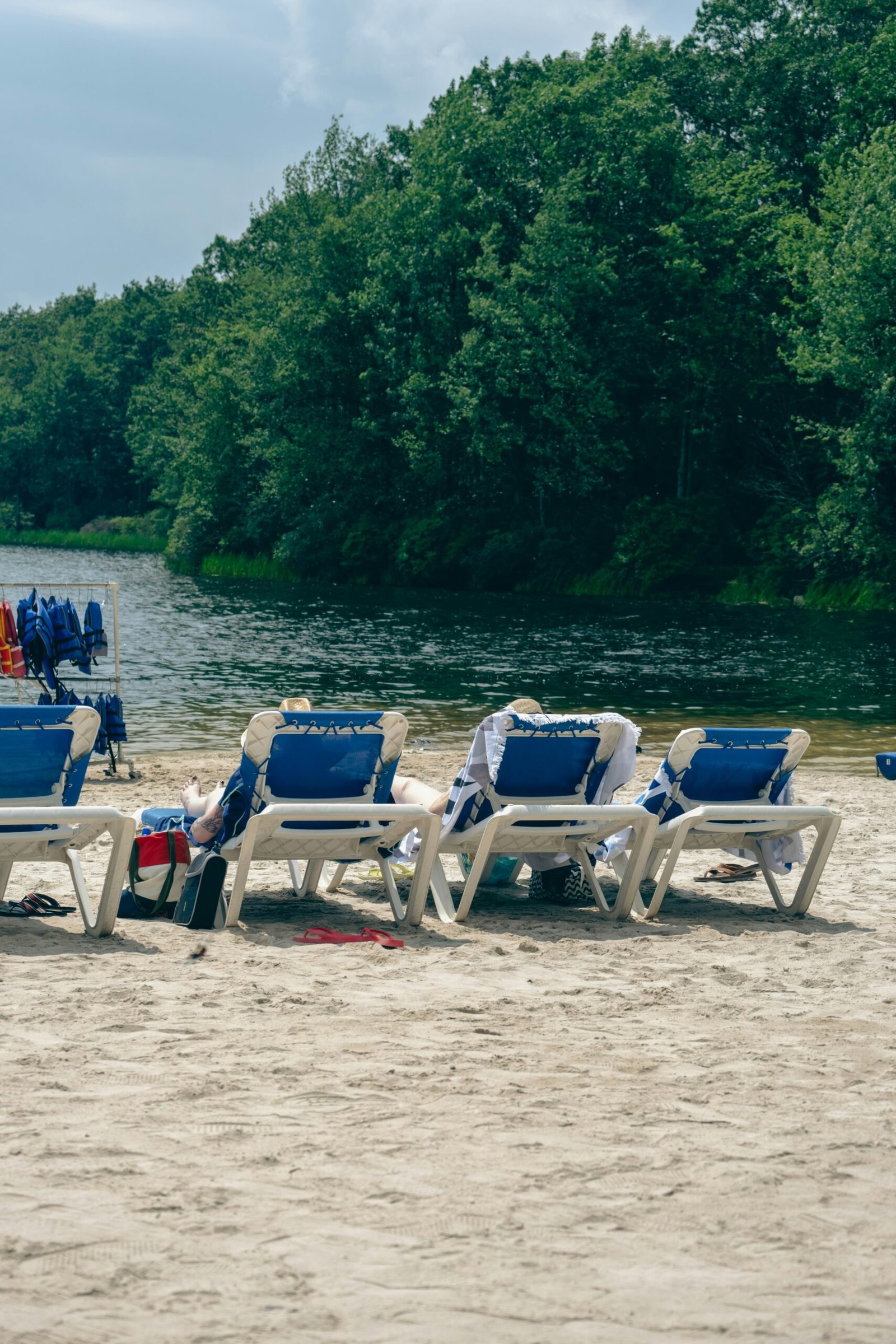 a row of lawn chairs sitting on top of a sandy beach